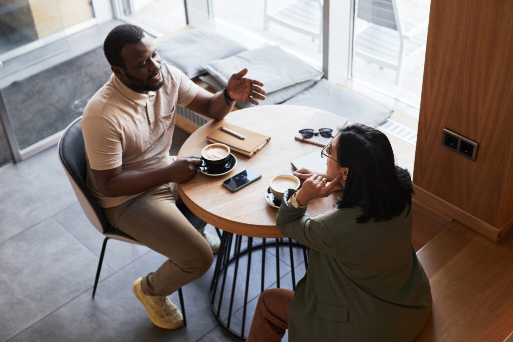 Two people having a discussion over coffee