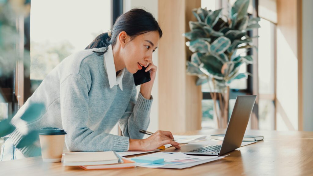 Woman talking on phone at computer