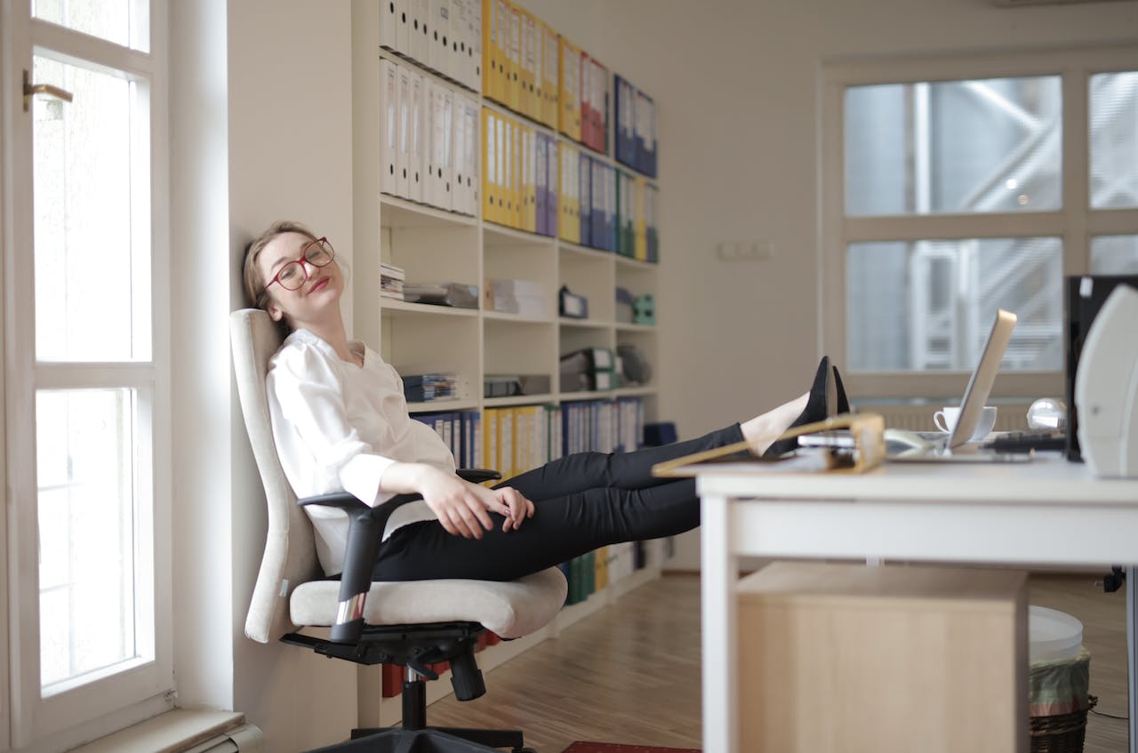Relaxed female with feet on table in workplace